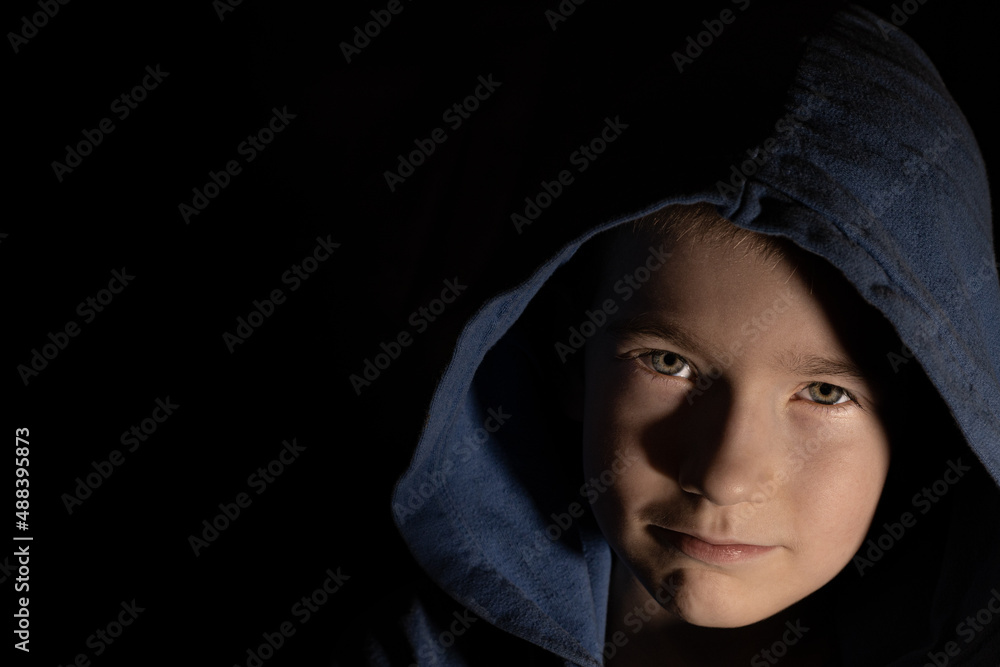 young boy in the hood. Dark portrait of a lonely child young boy in the hood. Dark portrait of a lonely child