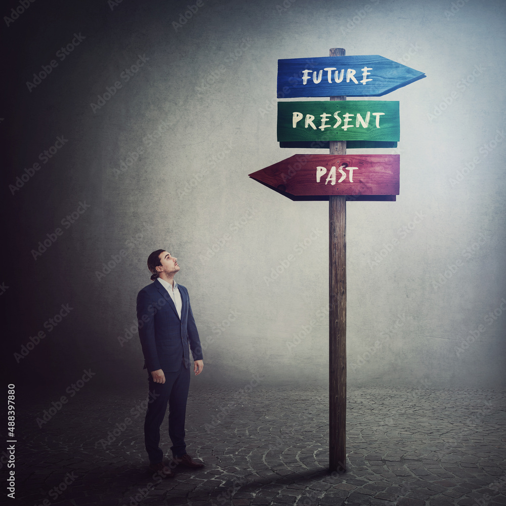 Businessman stands in front of a signpost showing three different ...