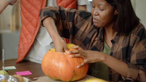 Принти на полотні A handsome young lady is carving the pumpkin