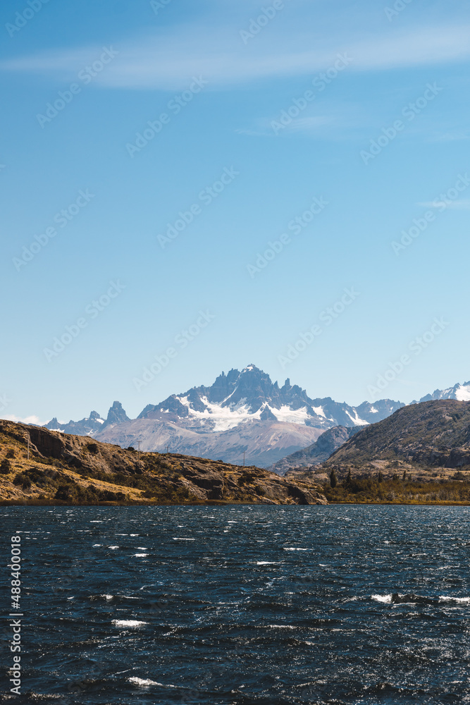 Large mountain range behind a navy blue lake. Patagonian landscape.