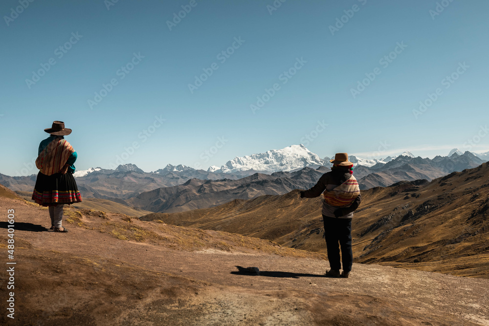 Typical Peruvian farmer at colourful Rainbow Mountains in Palccoyo (alternative to Vinicunca) with view of snow-covered Andes (Peru, South America)