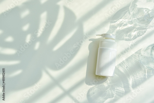 Obraz na płótnie Cosmetic bottle containers packaging with green herbal leaves in shadow and light effect, Blank label for organic branding mock-up, Natural skincare beauty product concept. w salonie