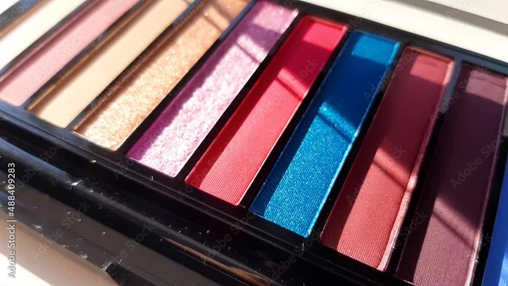 slow motion. a palette of bright eye shadows in close up. slow motion. a palette of bright eye shadows in close up.