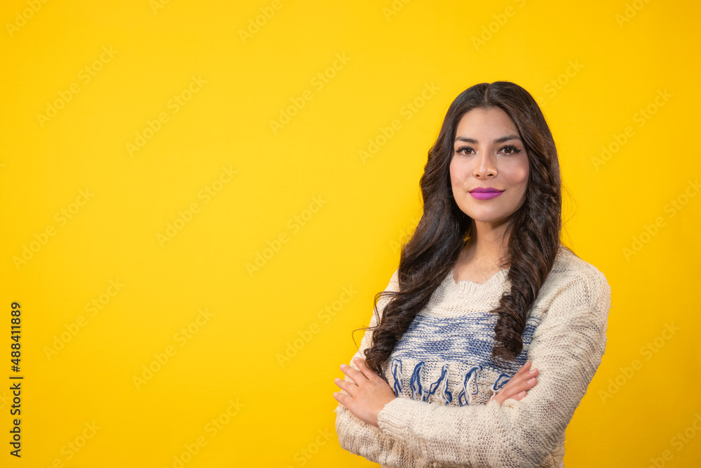 Happy woman with crossed arms on a yellow isolated background, young latin woman with a confident look on a yellow background, emotional security concept Happy woman with crossed arms on a yellow isolated background, young latin woman with a confident look on a yellow background, emotional security concept