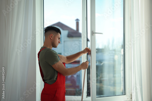 Worker putting rubber draught strip onto window indoors Free Download Worker putting rubber draught strip onto window indoors - GFXLoad