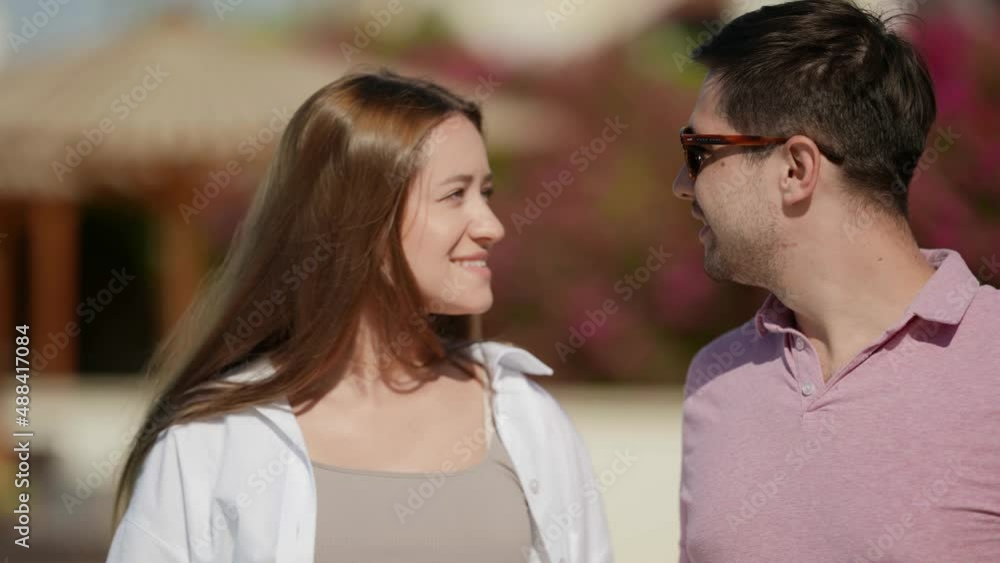 portrait of a woman with long hair in a white shirt and a man in dark glasses and a pink T-shirt on a sunny day. they look at each other, then kiss. close-up. the camera is moving portrait of a woman with long hair in a white shirt and a man in dark glasses and a pink T-shirt on a sunny day. they look at each other, then kiss. close-up. the camera is moving