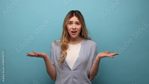 How could you. Portrait of annoyed angry woman raising arms, indignantly asking reason of failure, quarreling, wearing striped shirt. Indoor studio shot isolated on blue background.