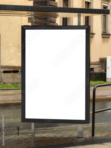 Empty advertisement display at a bus shelter in a city. Blank billboard mockup for marketing in the public sphere. Template for testing the design of an ad next to a street.