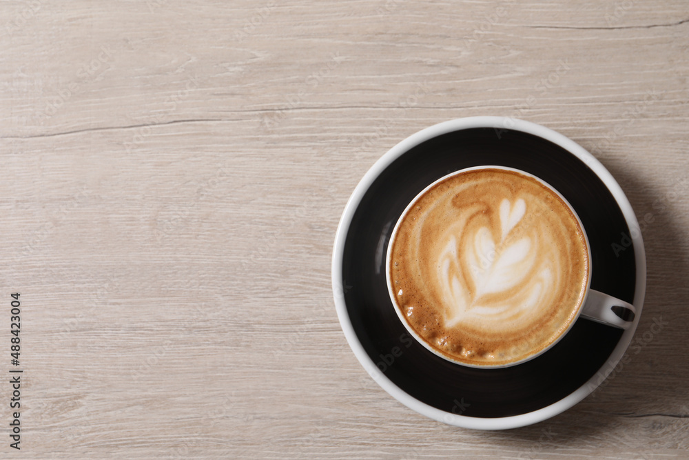 Cup of aromatic coffee on wooden table, top view. Space for text Cup of aromatic coffee on wooden table, top view. Space for text