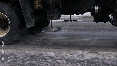 Big truck with snowplow blade and salter clearing street of snow. Toronto, Canada.