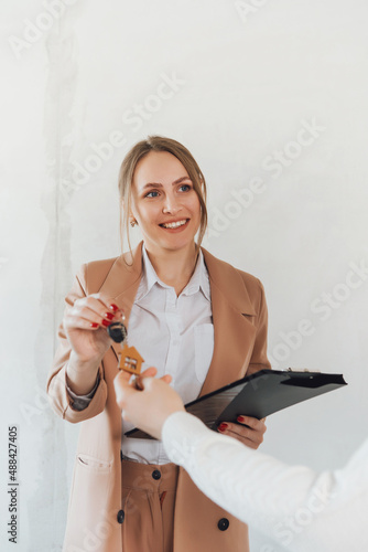 Real estate agent give keys with house keychain.