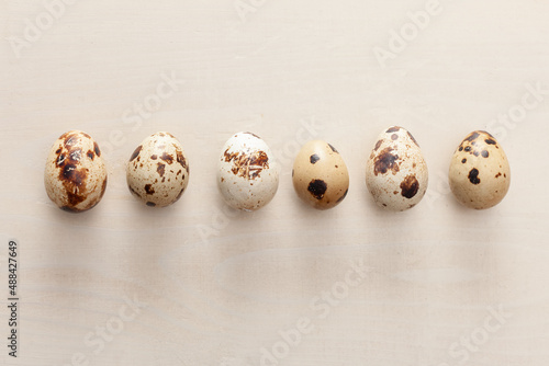 quail eggs arranged on white wooden background