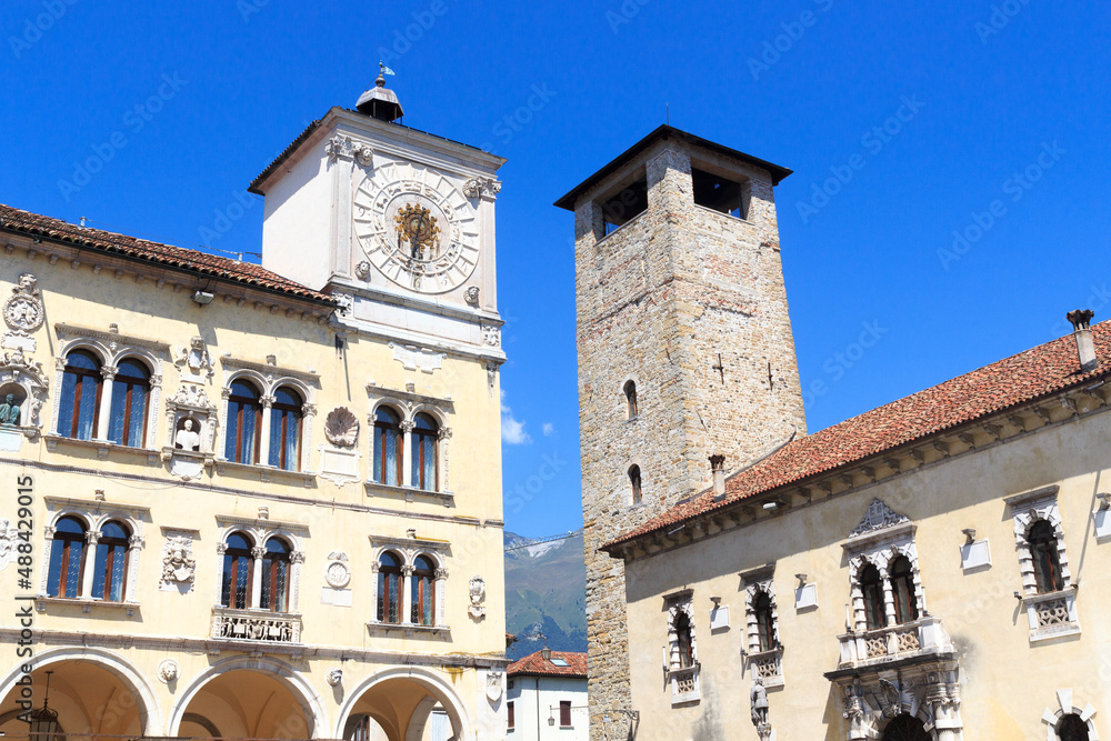 Palace Palazzo dei Rettori with arcade and clock tower at city square Piazza del Duomo in historic city of Belluno, Italy