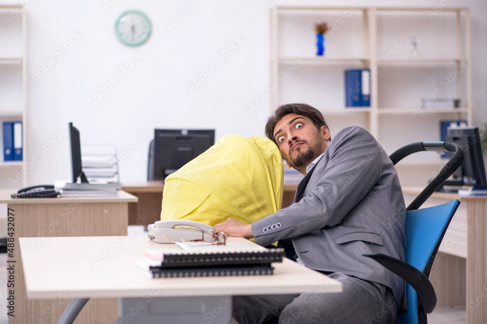 Young male employee looking after new born at workplace