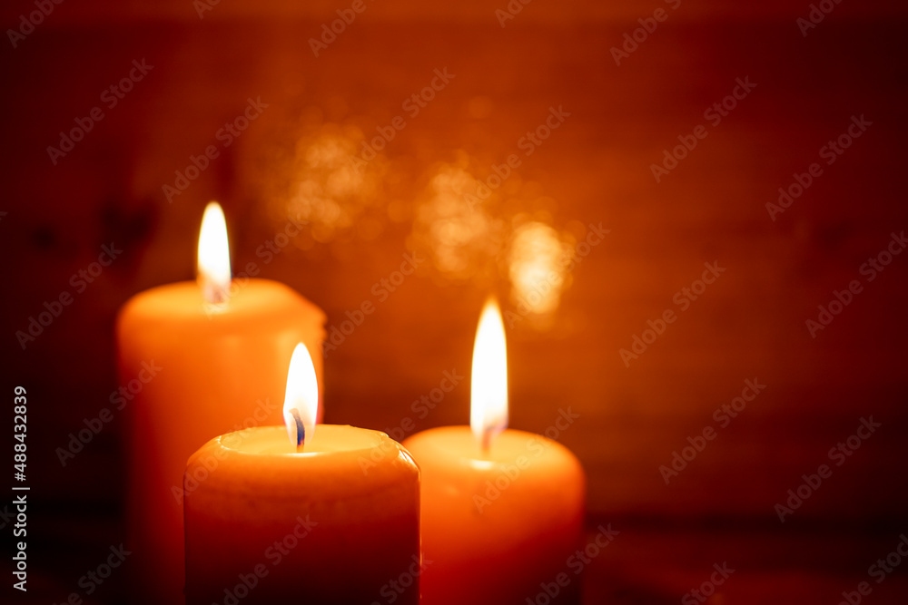 Burning candles on a wooden background.