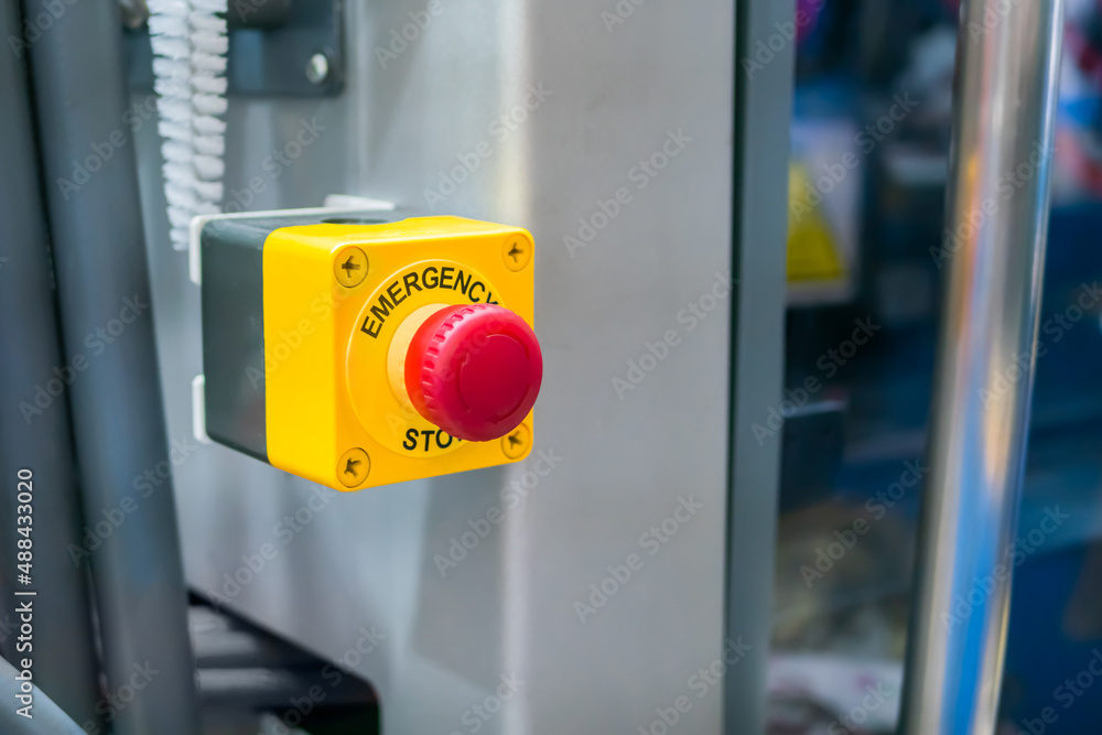 Close up view: machine control panel with power red switch button - emergency stop at factory, plant. Industrial, electronic, technology equipment concept