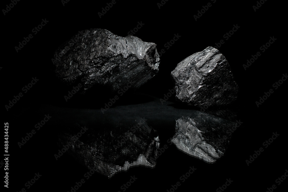 Naklejka premium Coals are reflected in the glass surface. Stylish photo for computer desktops and mobile home screens. Mineral carbon. A desktop picture. 