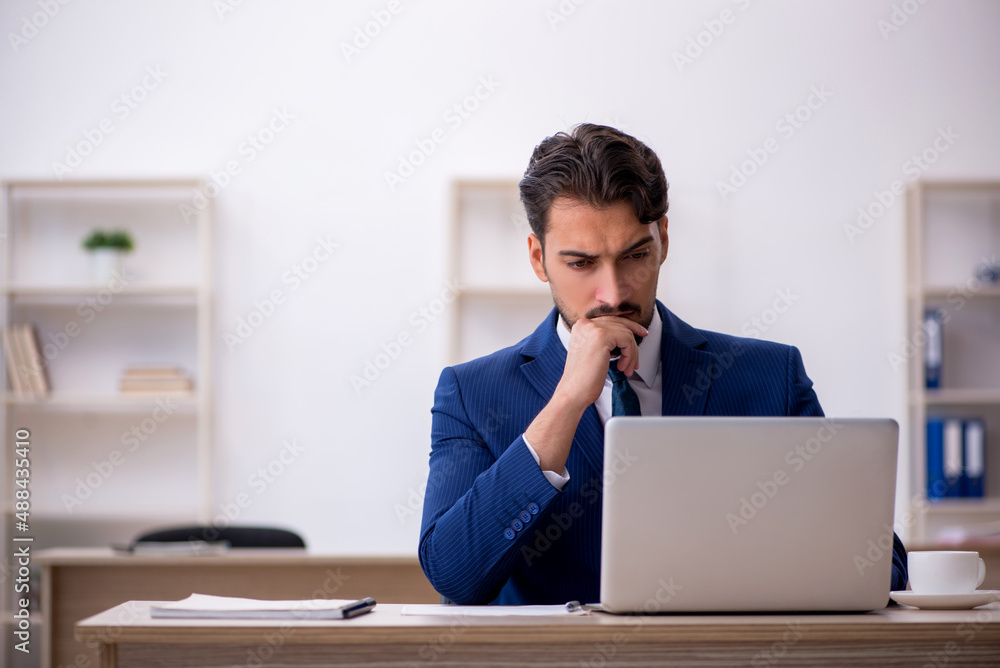 Young male employee working in the office Young male employee working in the office