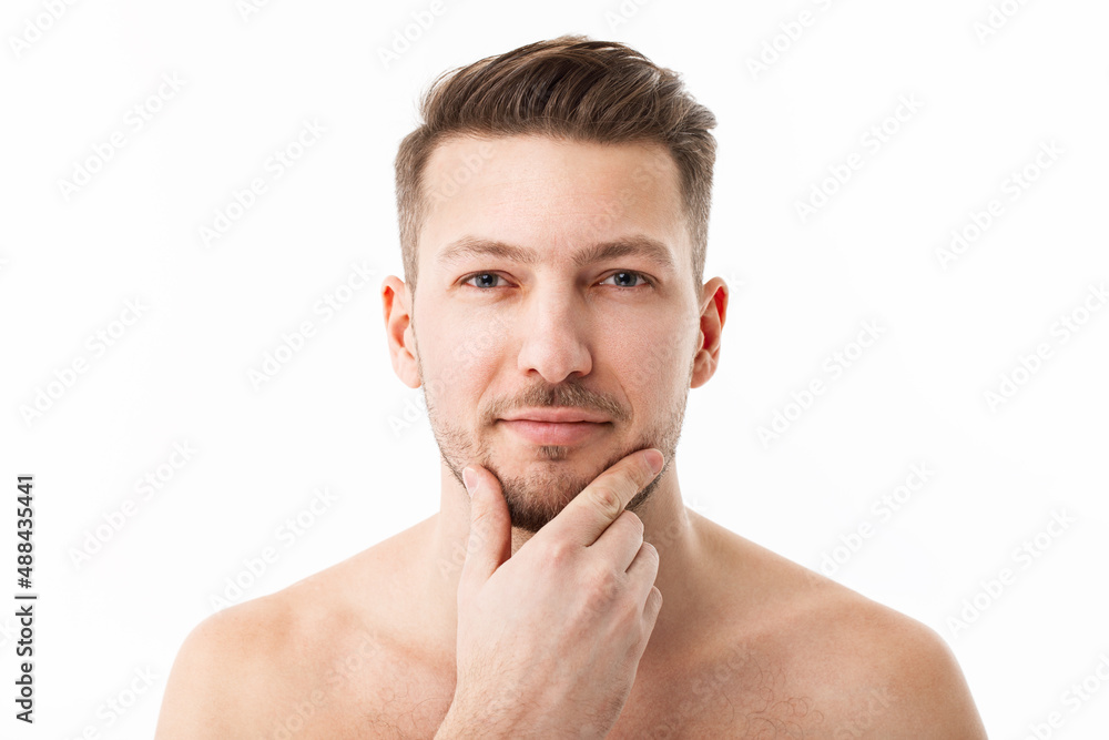 Portrait of a naked young man with stubble on a white background. Portrait of a naked young man with stubble on a white background.
