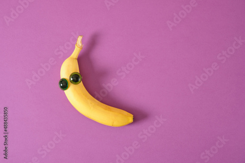 two banana face with eyes, carved cocetti merry face made of plastic doll eyes and a fresh yellow banana