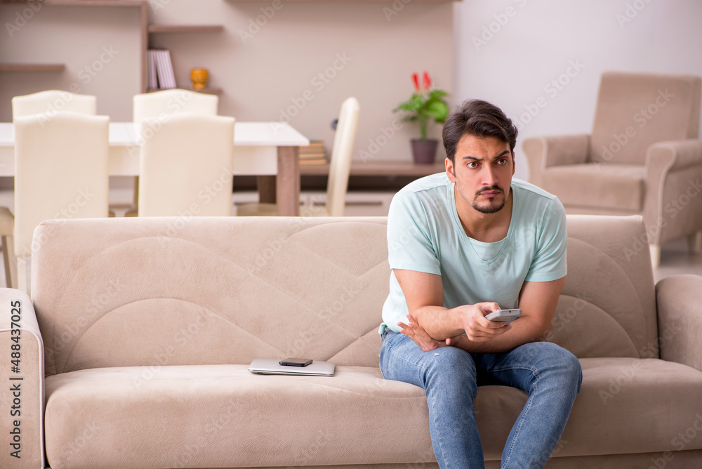 Young man student watching tv at home Young man student watching tv at home