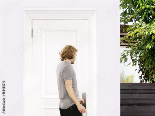 man opening the door of his home.