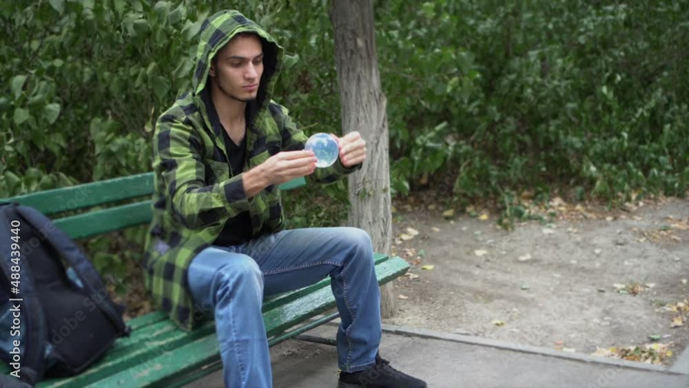Man shows trick with glass sphere. Artist is engaged in juggling.