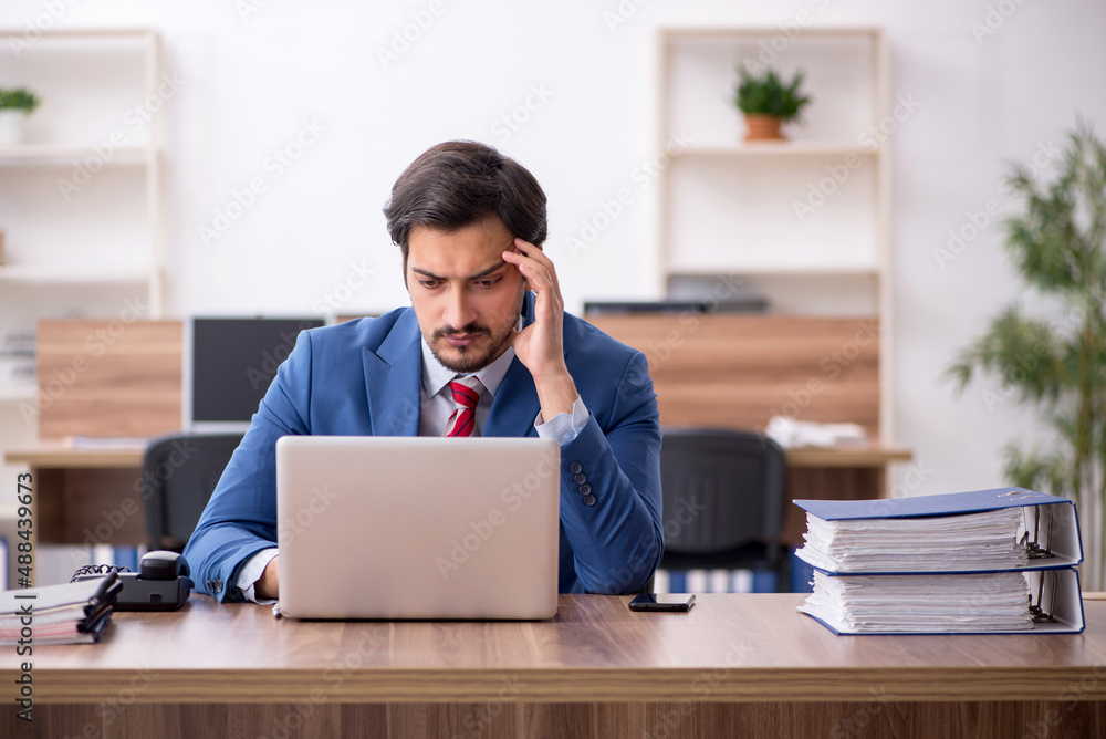 Young male employee sitting at workplace Young male employee sitting at workplace