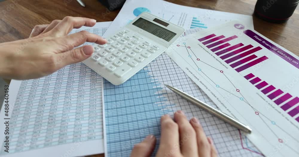 Accountant counting on calculator near documents with charts closeup 4k movie Accountant counting on calculator near documents with charts closeup 4k movie
