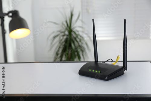 Obraz na płótnie Modern Wi-Fi router on table indoors. Space for text