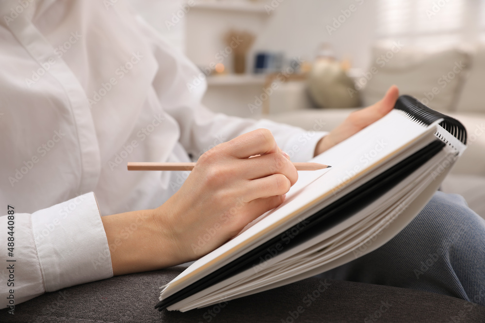 Woman drawing in sketchbook with pencil at home, closeup Woman drawing in sketchbook with pencil at home, closeup