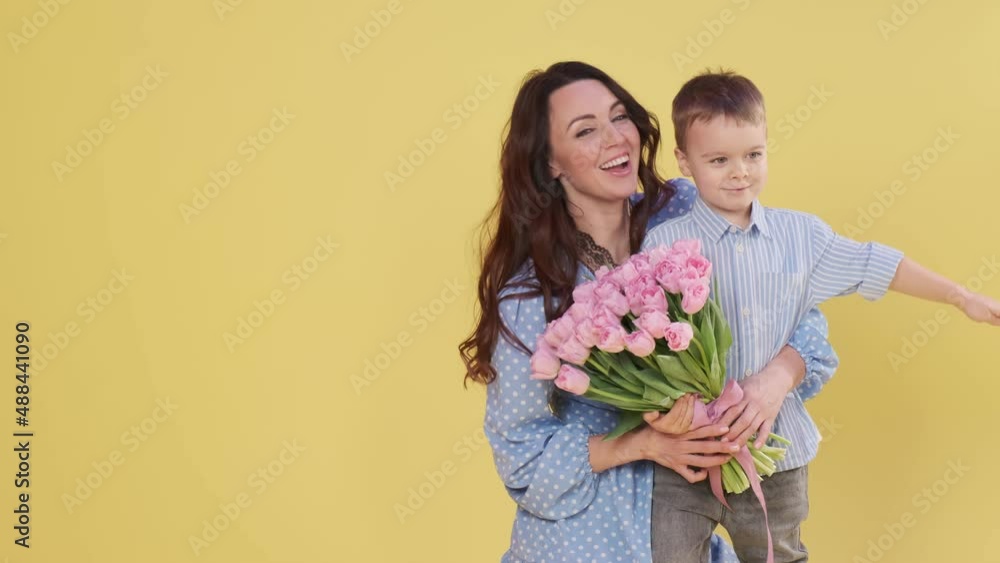 Adorable little boy is playing with his mom. Happy family mother and cute little boy son on yellow background having fun enjoying sweet moments together
Adorable little boy is playing with his mom. Happy family mother and cute little boy son on yellow background having fun enjoying sweet moments together