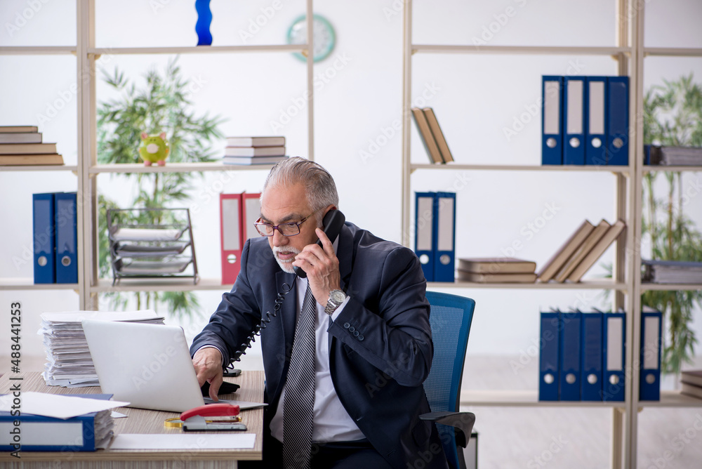 Old male employee and too much work in the office Old male employee and too much work in the office