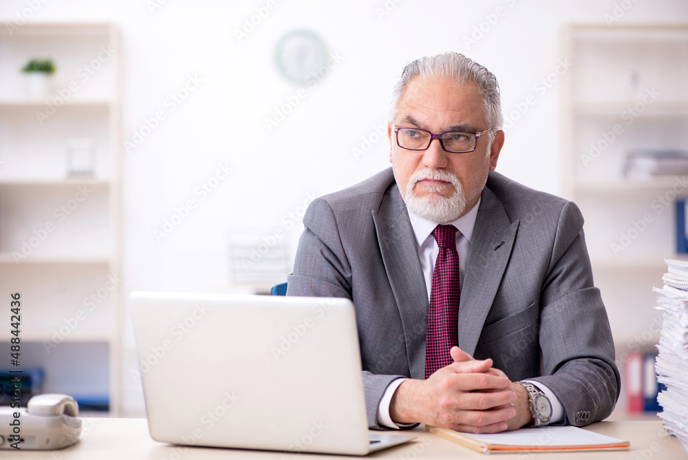 Old male employee and too much work in the office Old male employee and too much work in the office