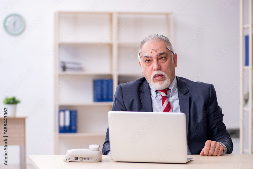 Old male employee working in the office Old male employee working in the office