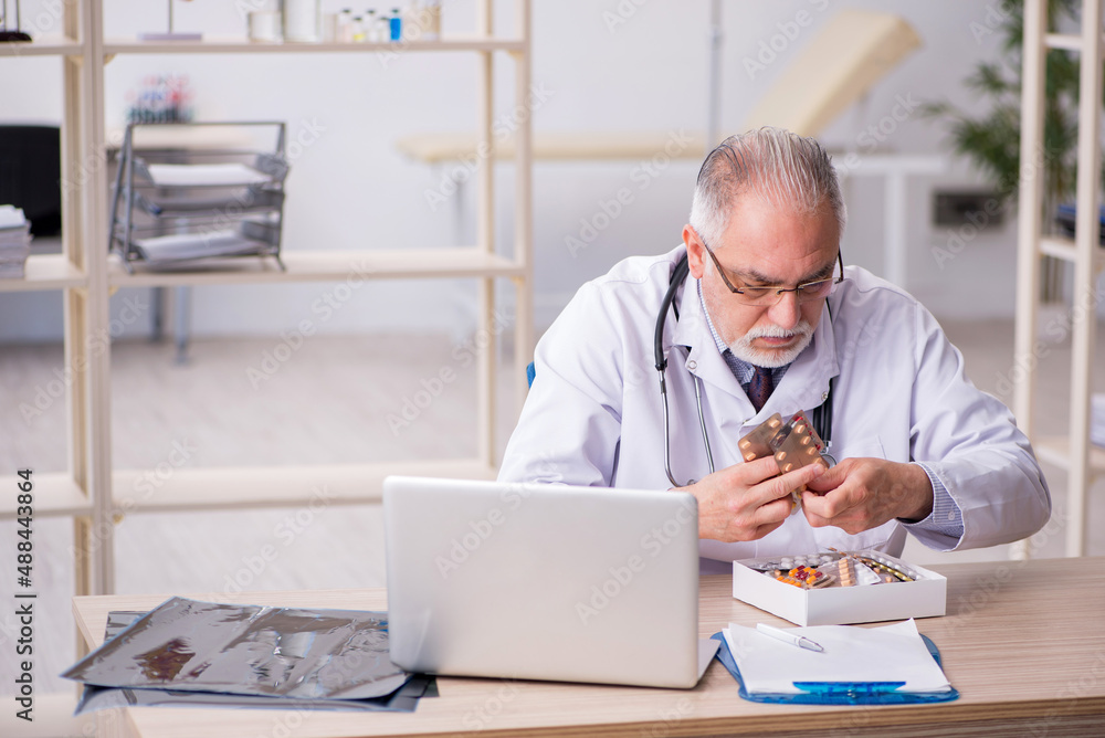 Old male doctor working in the clinic Old male doctor working in the clinic