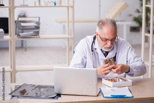 Old male doctor working in the clinic