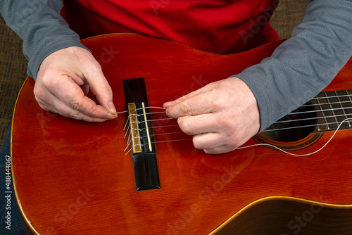 replacement and insertion of nylon strings in a classical guitar. lesson for a musician photo