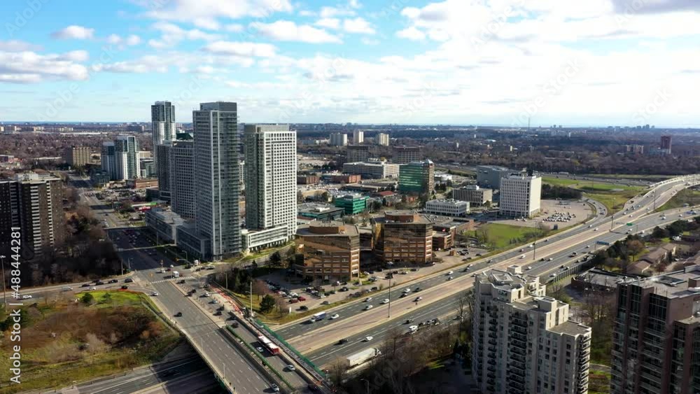 Don Valley Parkway going towards condos with traffic underneath blue skies and clouds Don Valley Parkway going towards condos with traffic underneath blue skies and clouds