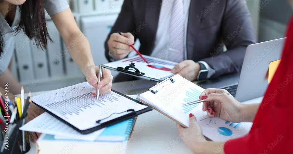 Successful team of analysts is studying financial charts Successful team of analysts is studying financial charts