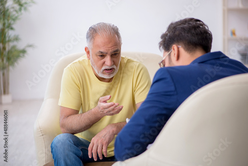 Old man visiting young male psychotherapist