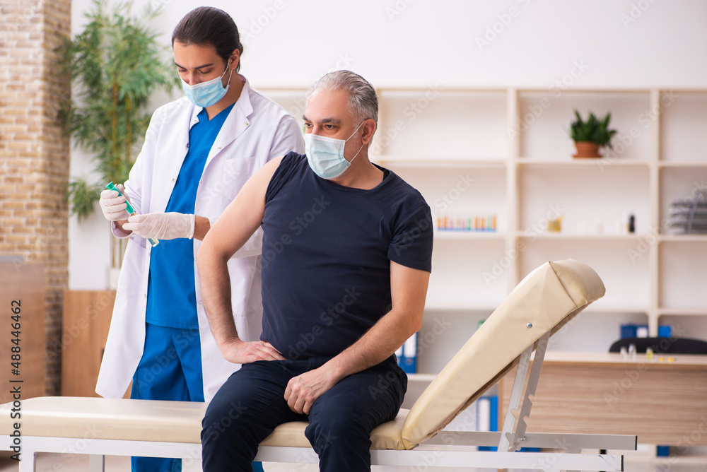 Old man visiting young doctor in covid-19 vaccination concept Old man visiting young doctor in covid-19 vaccination concept