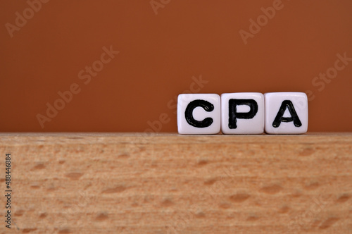 Word cubes lined up with the letters CPA written on it. It is an abbreviation for Cost per Acquisition. Copy space available.