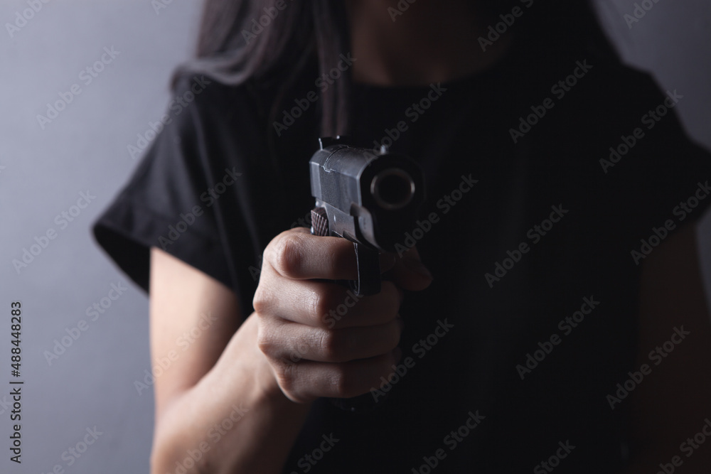 the girl is holding a gun in her hand. the girl is holding a gun in her hand.