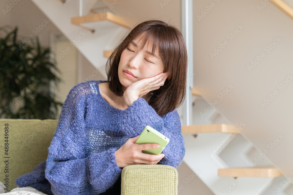 部屋でスマホを見る女性 考える 部屋でスマホを見る女性 考える