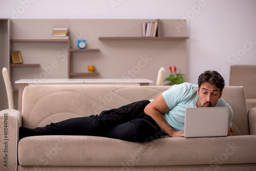 Young man sitting on the sofa with computer at home