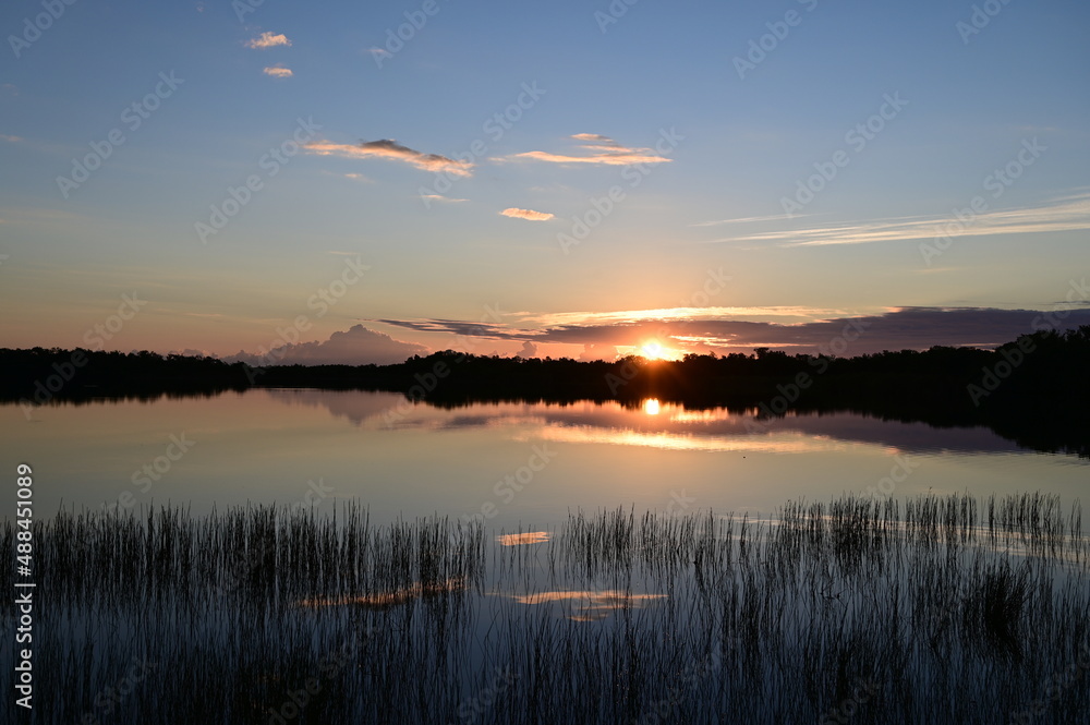 Sunrise cloudscape reflected in tranquil water of Nine Mile Pond in Everglades National Park, Florida.
