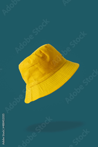 yellow bucket hat, blue background