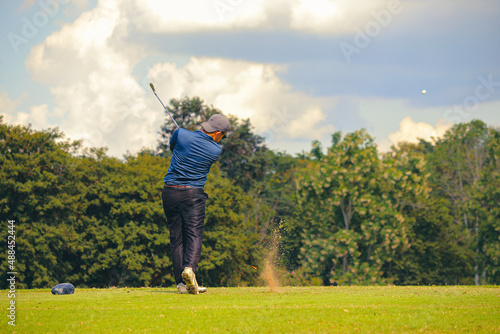 Man Playing Golf on Beautiful Day Green Golf Course.