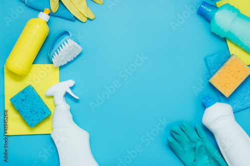 Cleaning kit detergents napkins sponges gloves, blue background. The concept of home cleaning or cleaning company services